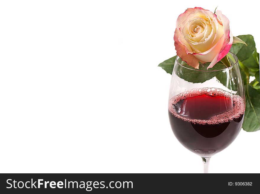 A glass of red wine with rose isolated on white