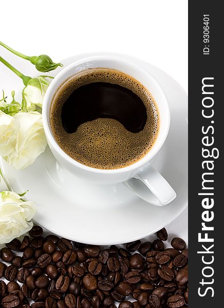 A cup of coffee with white roses and coffee beans isolated on white. A cup of coffee with white roses and coffee beans isolated on white