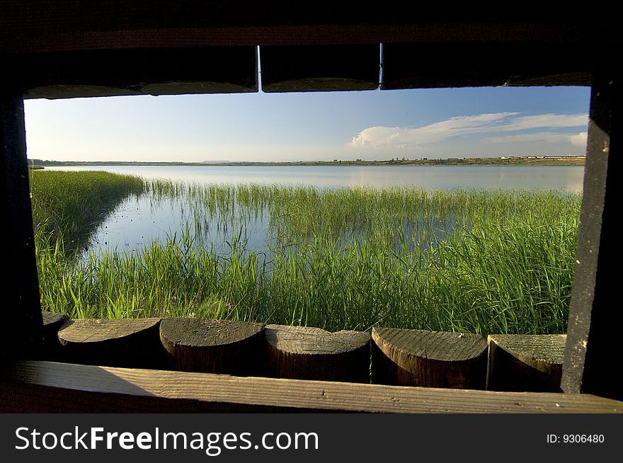 Window of a wood hide in a lake