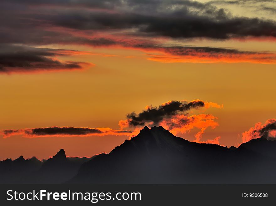 Clouds over the Swiss Alps, illuminated by the last rays of the setting sun. Clouds over the Swiss Alps, illuminated by the last rays of the setting sun.