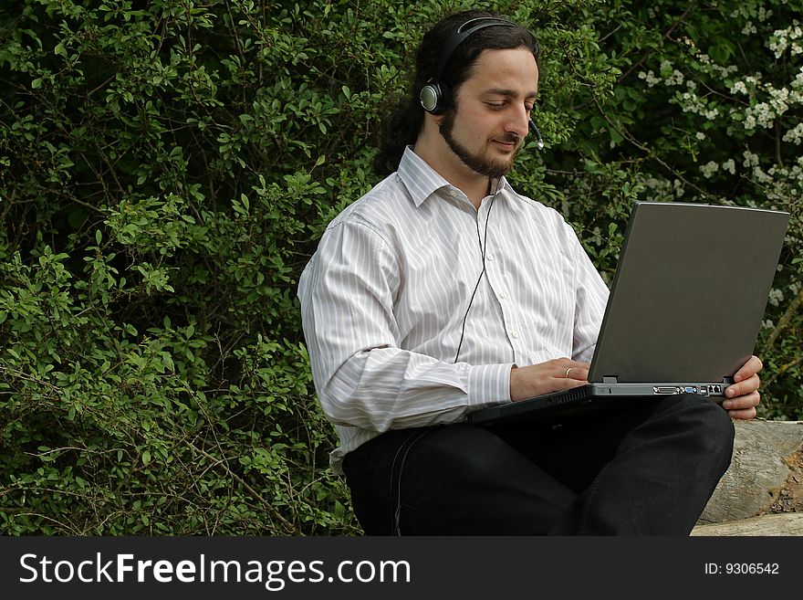 A man with headset, working outside. A man with headset, working outside