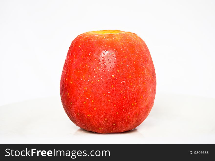 Big Red Apple with water droplets on the textured skin