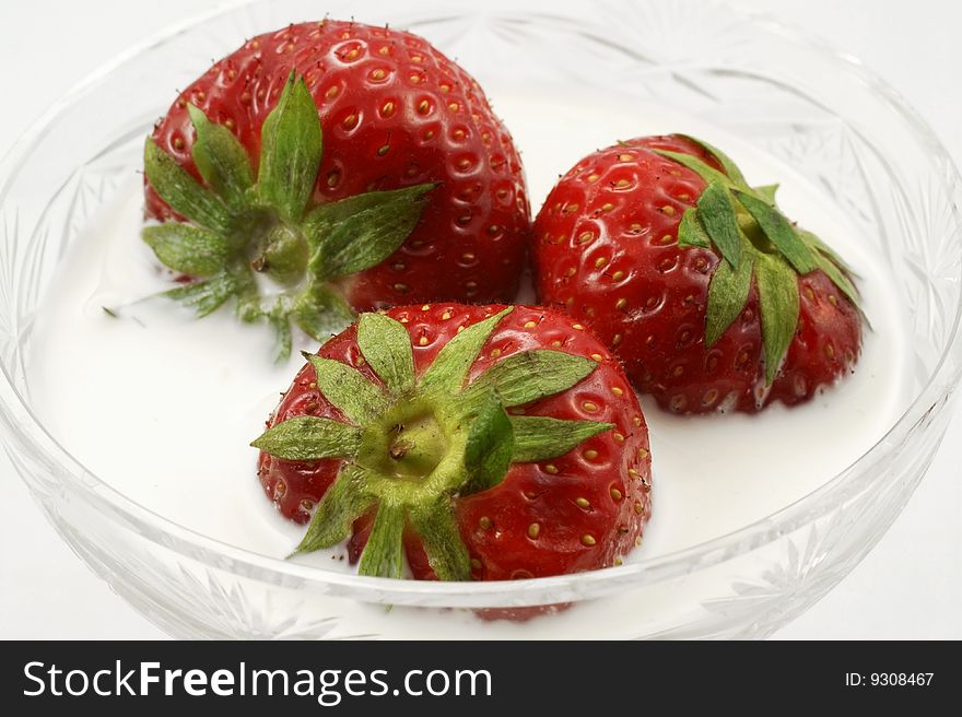 The ripe strawberry with cream, is photographed on a white background. The ripe strawberry with cream, is photographed on a white background
