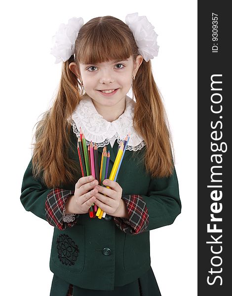 A smiling girl with color pencils in hands on a white background. Schoolgirl is holding coloured pencils.