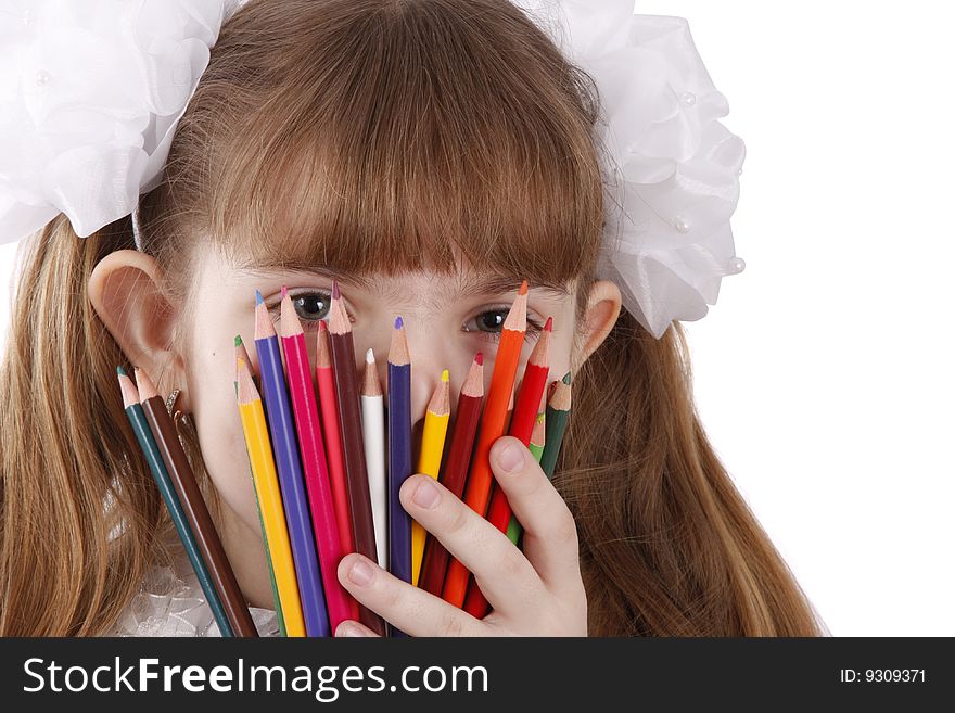 A smiling girl with color pencils in hands on a white background. Schoolgirl is holding coloured pencils. A smiling girl with color pencils in hands on a white background. Schoolgirl is holding coloured pencils.