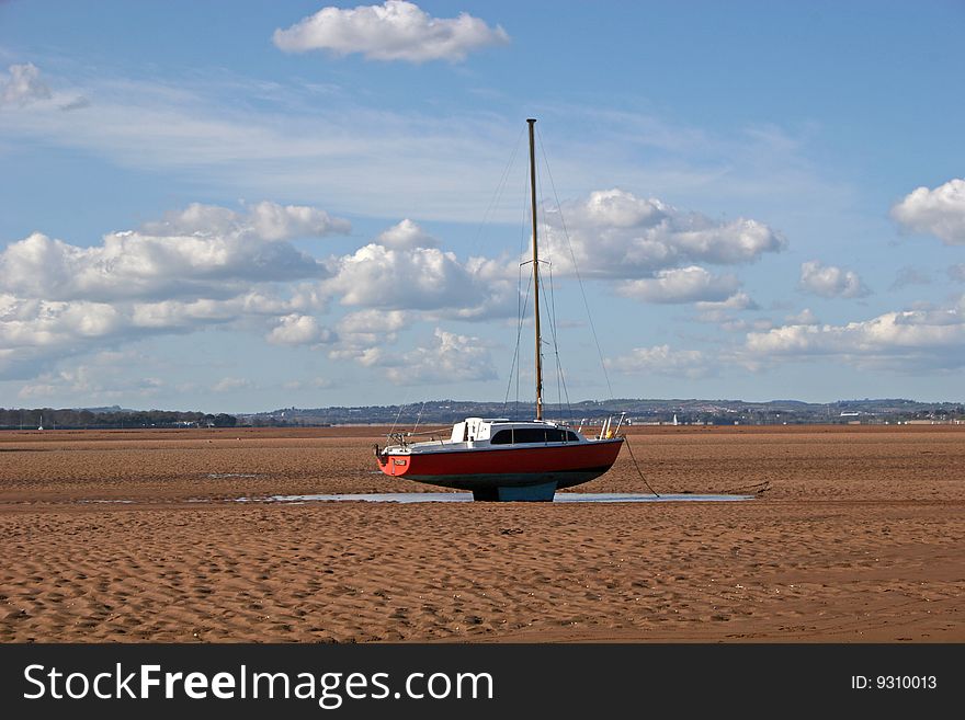 Yacht in river estuary at low tide