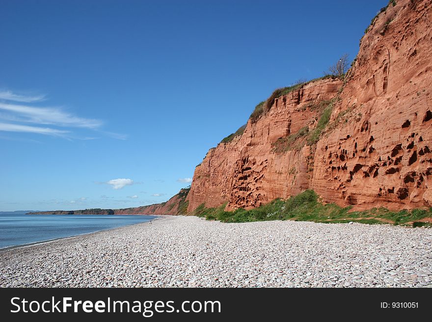 Sandstone cliffs beside shingle beach. Sandstone cliffs beside shingle beach