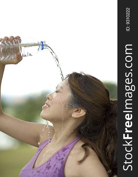 An asian female cooling off by pouring lots of water on the face. An asian female cooling off by pouring lots of water on the face.