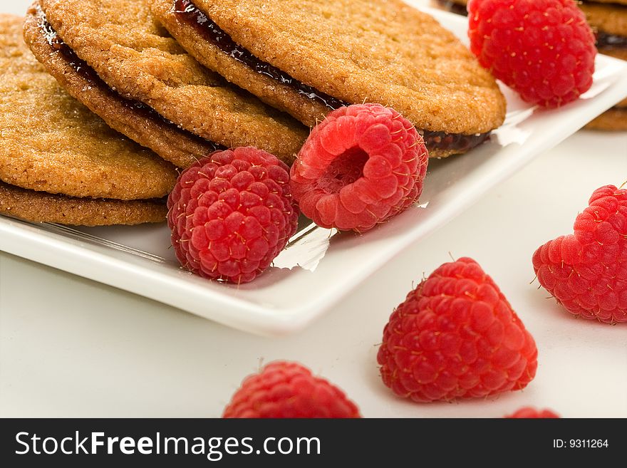 Raspberry ginger snaps on square white plate with raspberries