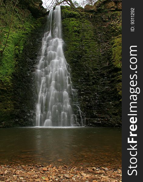 A waterfall over rocks into a deep pool