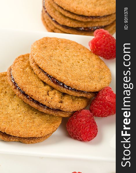 Raspberry ginger snaps on square white plate with raspberries