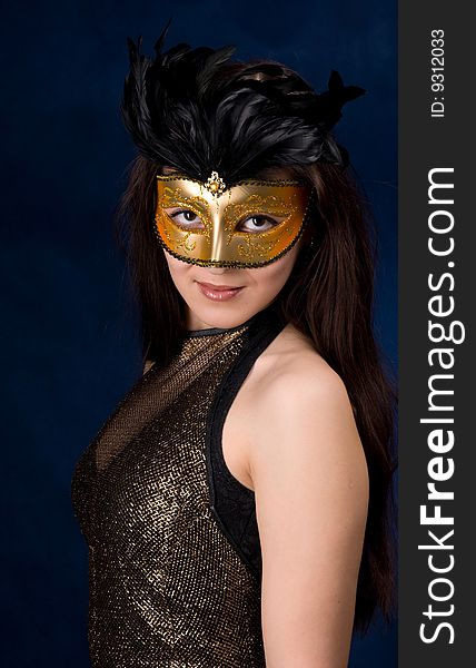 The young girl in a mask, is photographed on a dark blue background. The young girl in a mask, is photographed on a dark blue background