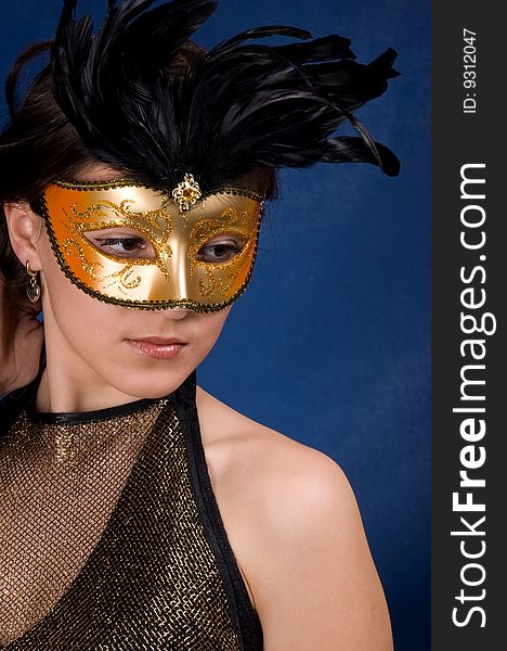 The young girl in a mask, is photographed on a dark blue background. The young girl in a mask, is photographed on a dark blue background