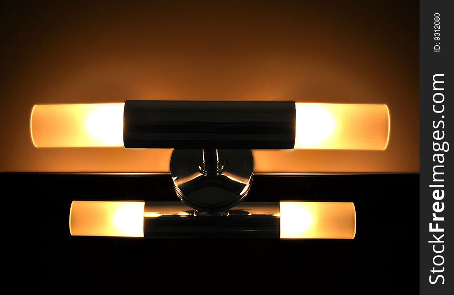 Closeup of an unusual, stylish interior lamp, emitting a soft warm glow. Closeup of an unusual, stylish interior lamp, emitting a soft warm glow.