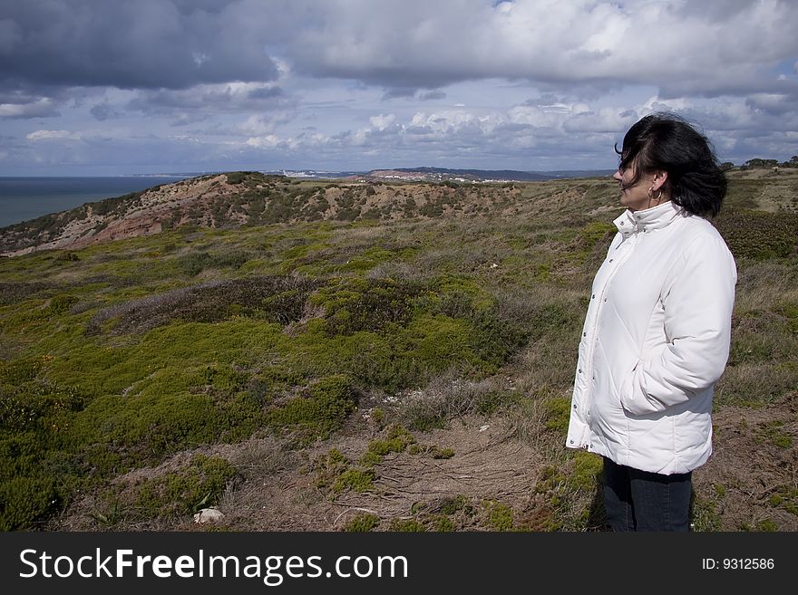 Woman contemplating the landscape on top of the mountain