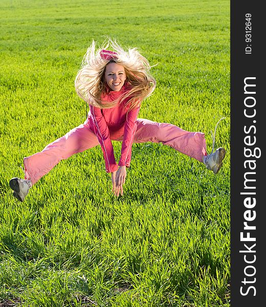 Beautiful young woman jumps above green meadow. Beautiful young woman jumps above green meadow