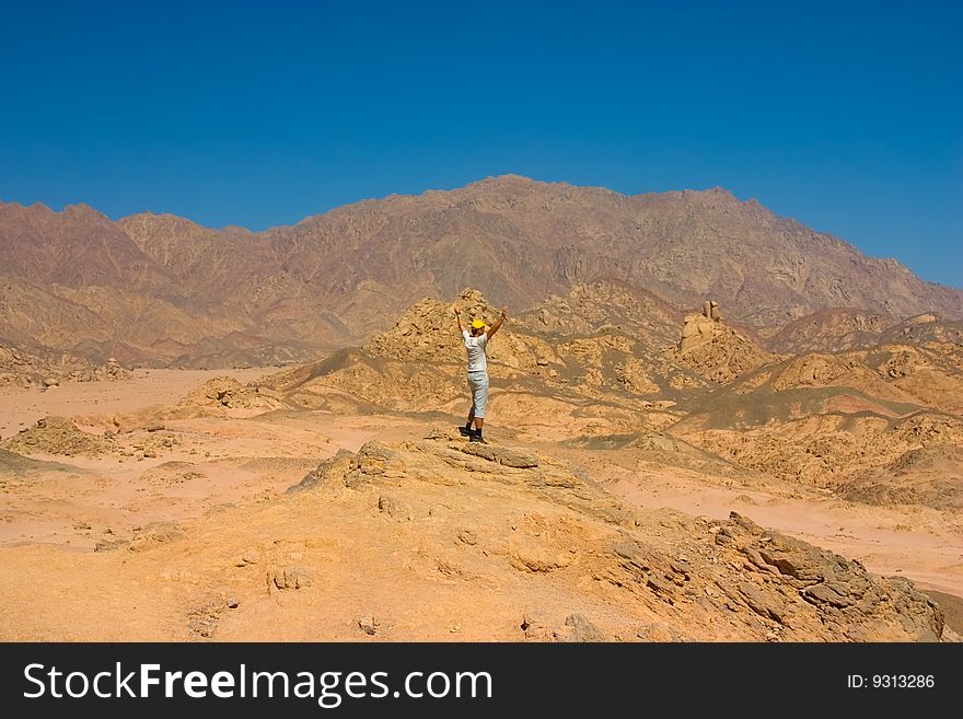 Man on the top of hill in desert