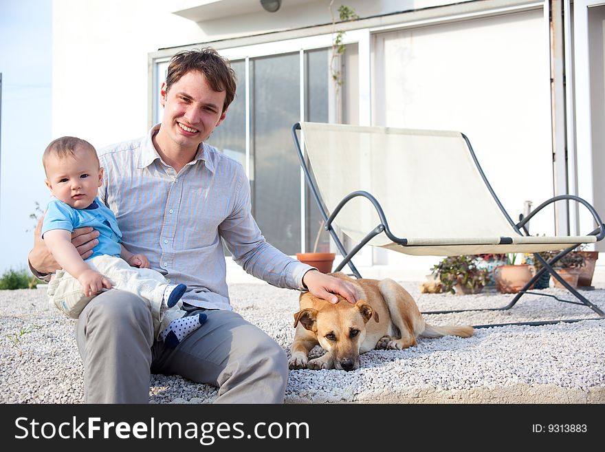 Father with his baby son and dog in front of a house. Father with his baby son and dog in front of a house