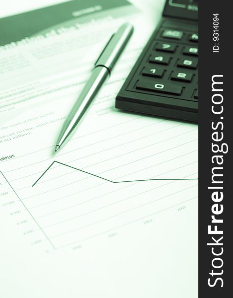 Pencil and calculator over chart report