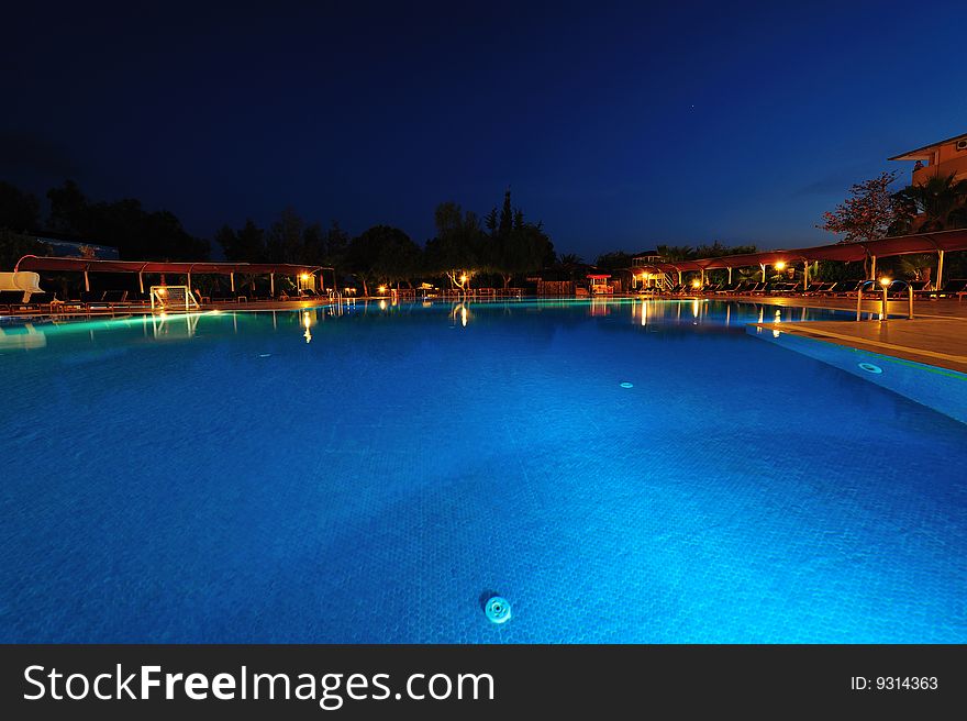 Night time photo of a swimming pool at a tropical resort