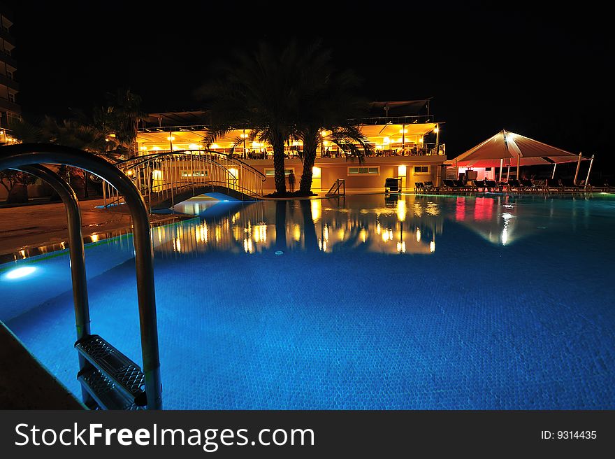 Night time photo of a swimming pool at a tropical resort