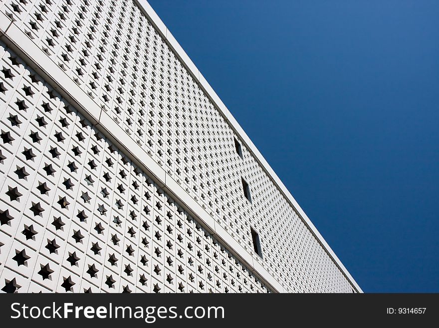 A view of the white facade of a Japanese building against a blue sky. A view of the white facade of a Japanese building against a blue sky
