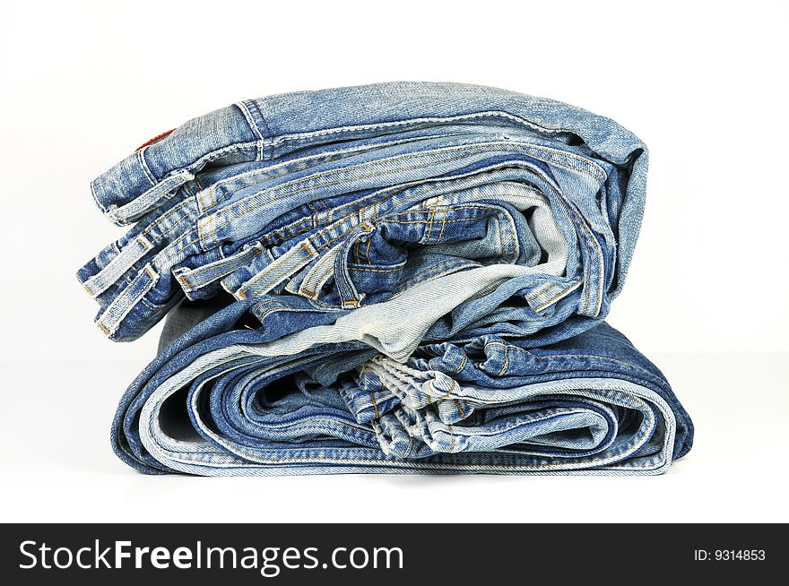 Stack of washed-out folded blue jeans isolated on white. Stack of washed-out folded blue jeans isolated on white