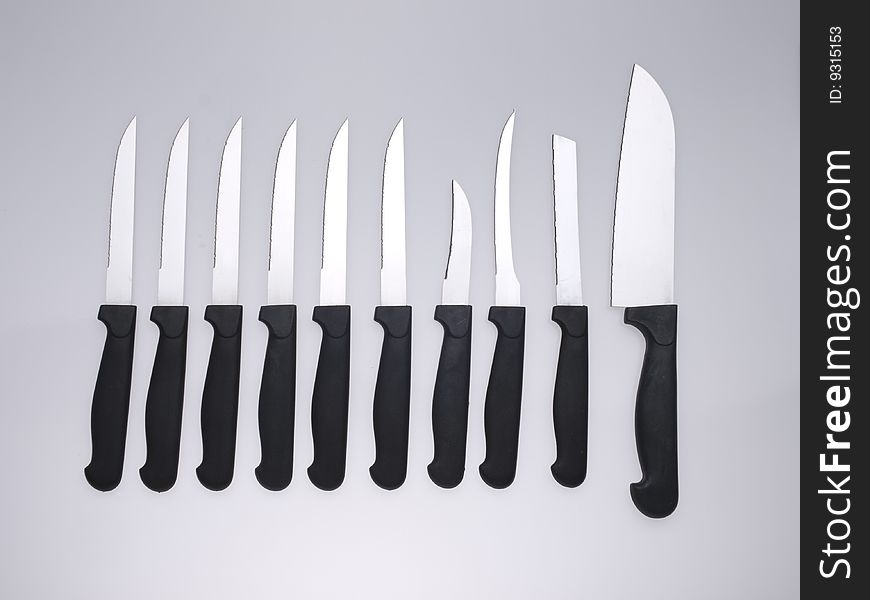 A set of ten knives isolated on a grey background. A set of ten knives isolated on a grey background.