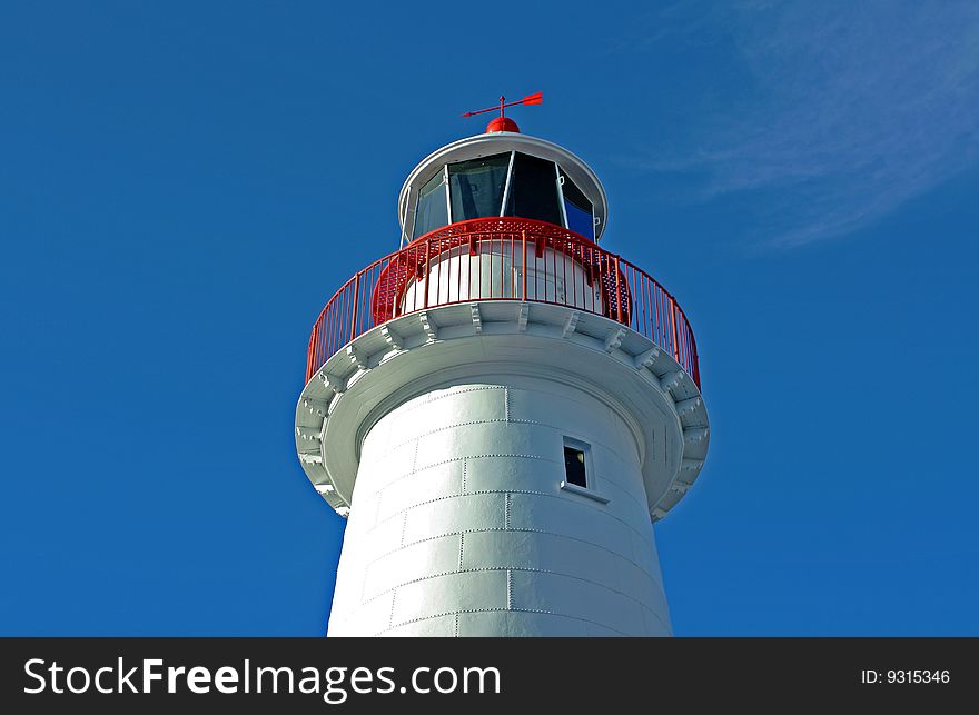 Looking up at a lighthouse against a clear blue sky. Looking up at a lighthouse against a clear blue sky