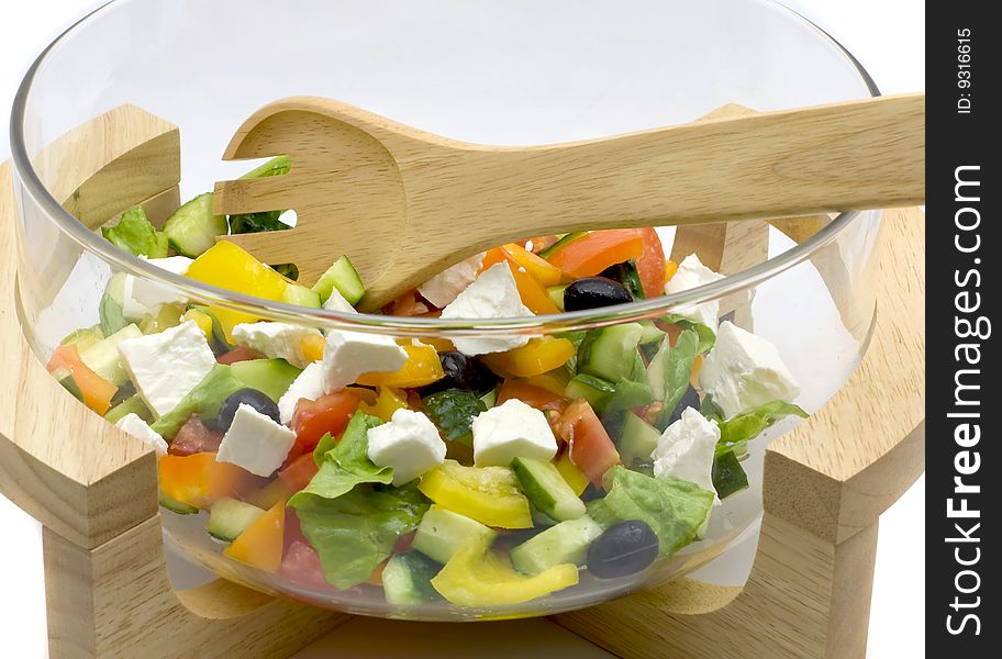 Bowl with vegetable salad and a wooden spoon