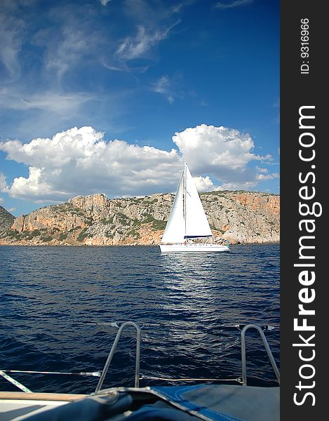 White yacht sail near shore in the sea