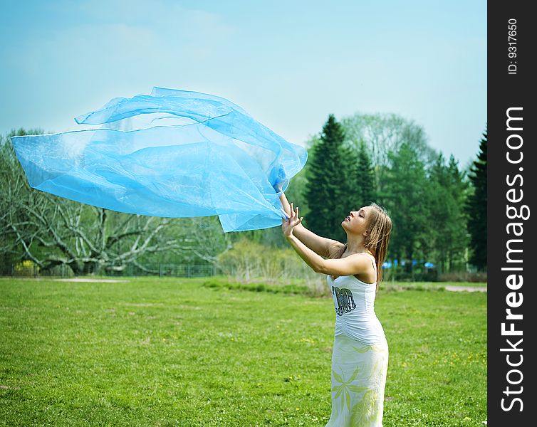 Woman dancing on the park with a blue sarong