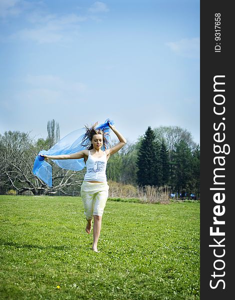 Woman dancing on the park with a blue sarong