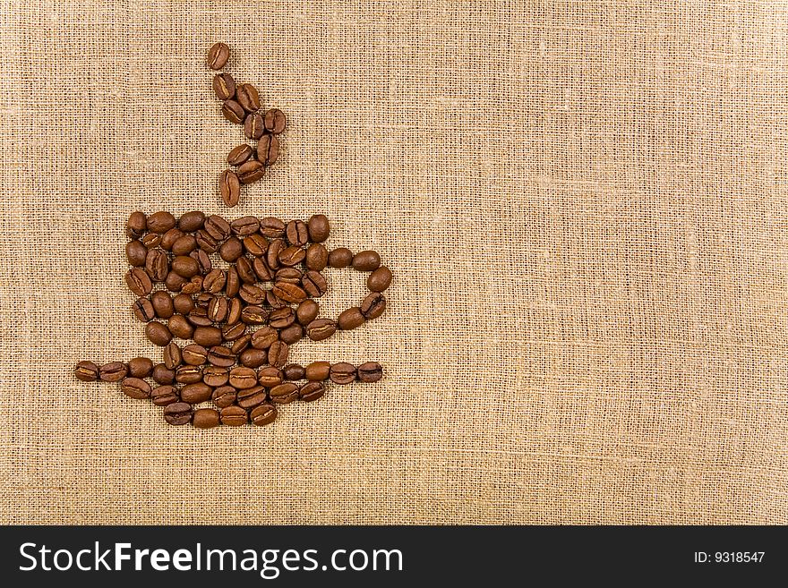 Coffee cup made of beans over canvas background, lot of copy-space. Coffee cup made of beans over canvas background, lot of copy-space