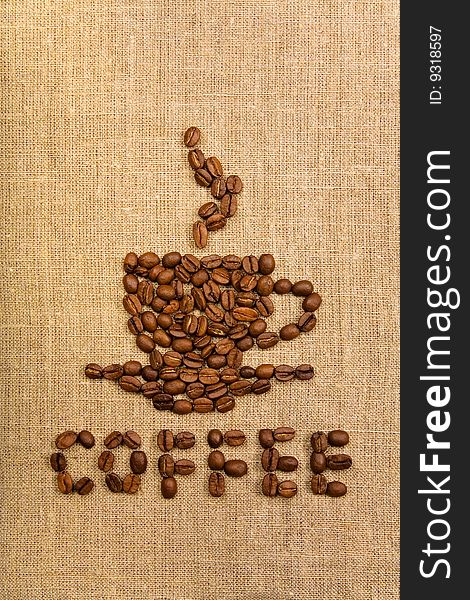 Coffee cup made of beans over canvas background. Coffee cup made of beans over canvas background
