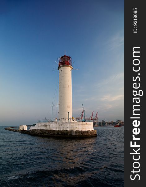 Lighthouse, industrial docks on background