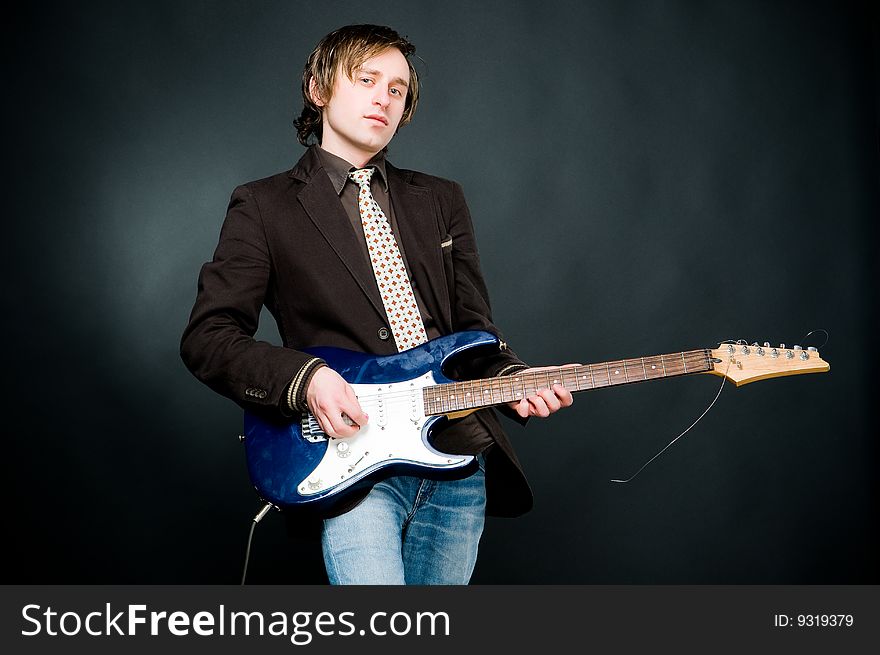 Man playing electro guitar, studio shot