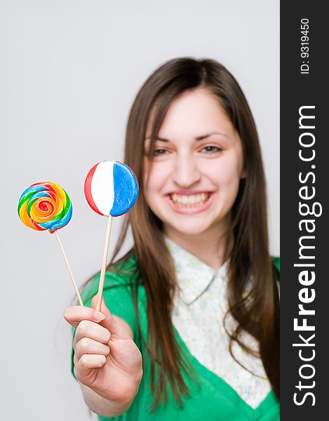 Smiling girl with lollipops, focus on sweets