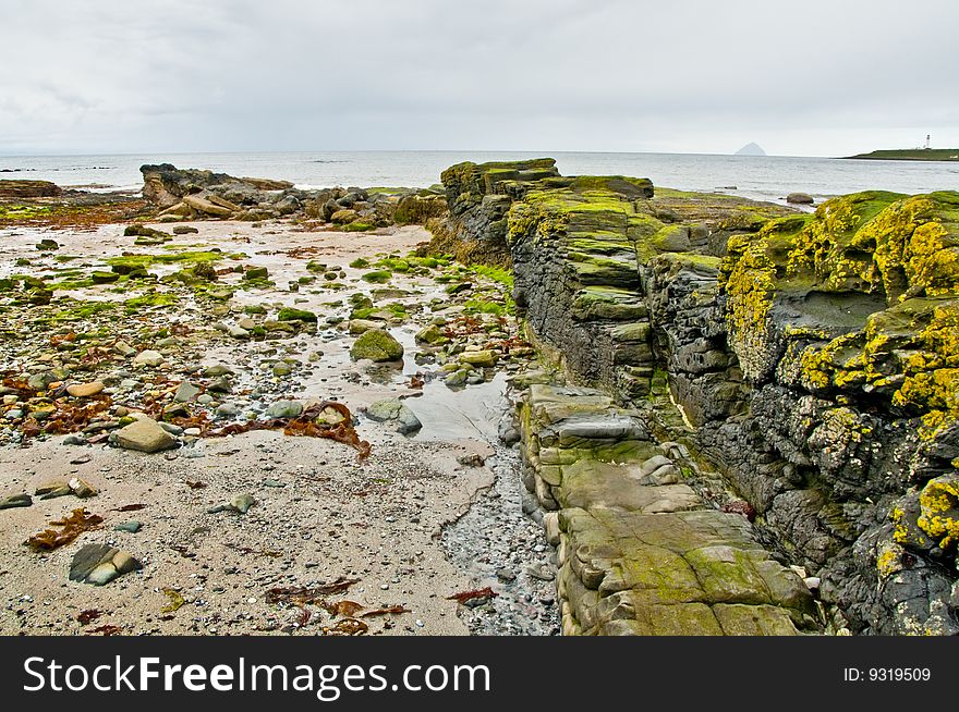 View down dyke on Arran coast with islands in the distance