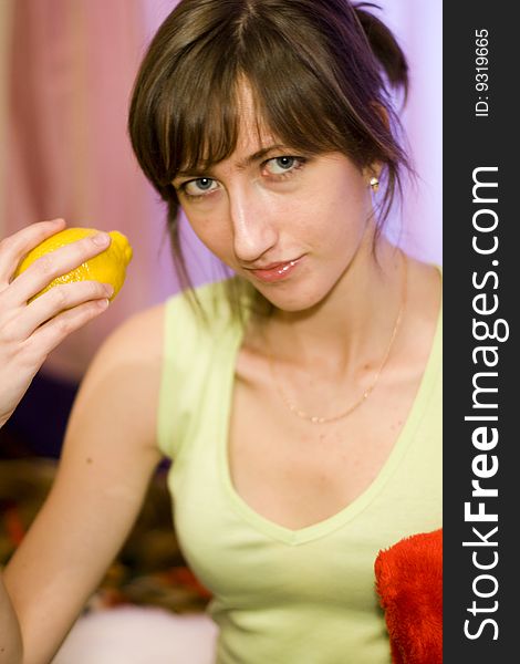 A girl holds in her hand a yellow lemon. Feeling lusciousness. A girl holds in her hand a yellow lemon. Feeling lusciousness