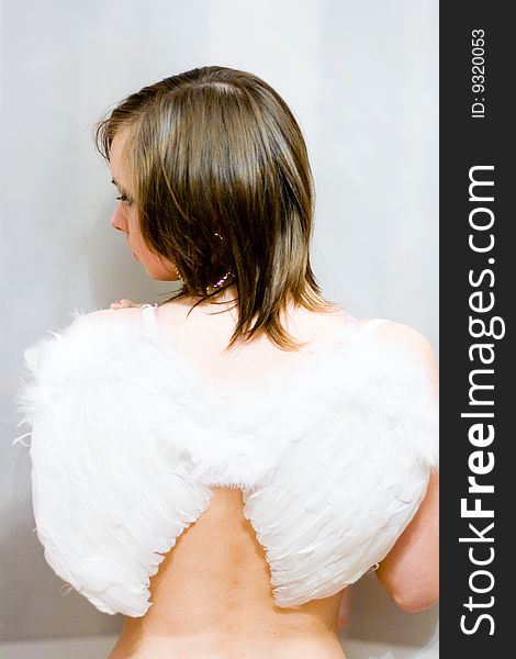 Beautiful girl with white wings behind their backs. Beautiful girl with white wings behind their backs