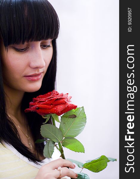 Girl sniffing beautiful flower - red rose. Girl sniffing beautiful flower - red rose
