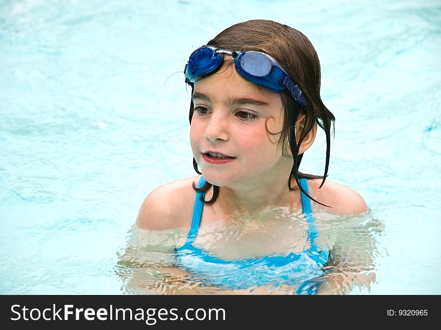 A young girl enjoying the swimming pool on a hot day at home, camp or vacation. 5 years old. A young girl enjoying the swimming pool on a hot day at home, camp or vacation. 5 years old