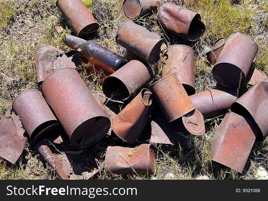 Pile of old rusted tin cans out in grass. Pile of old rusted tin cans out in grass