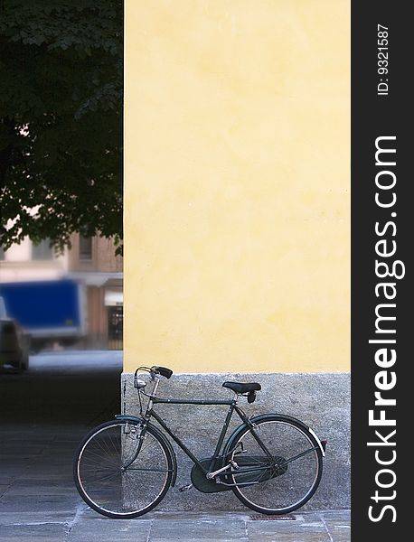 Bicycles chained near an old wall