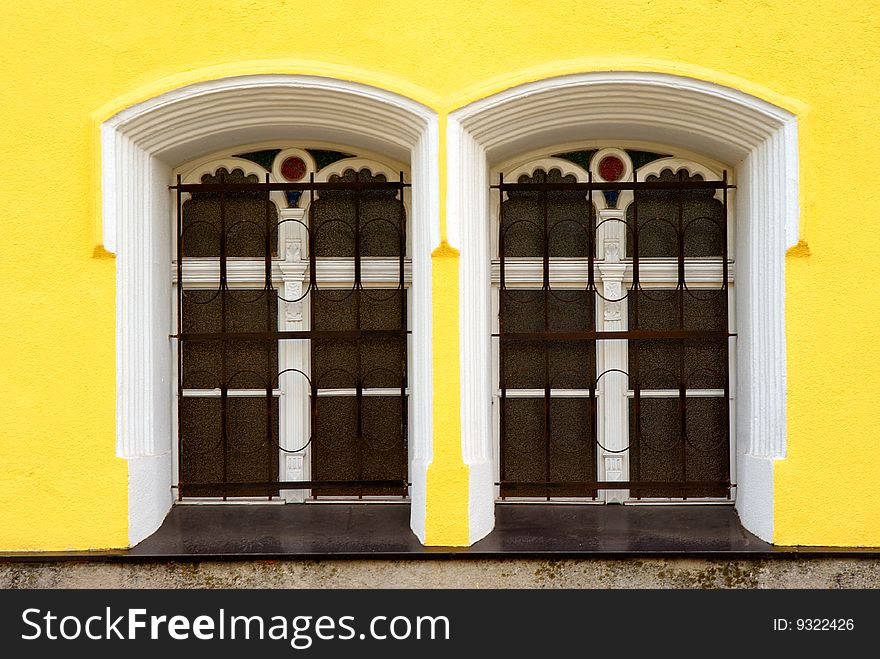 Two windows on yellow facade