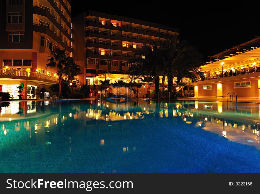 Night time photo of a swimming pool at a tropical resort