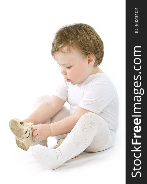 Child with shoes sitting. Isolated on white