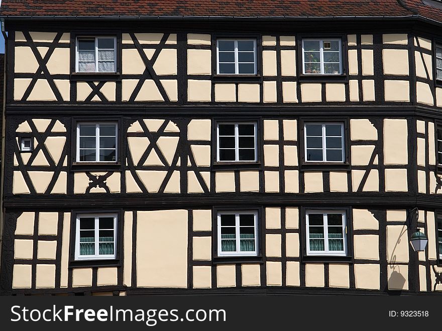 Half-timbered houses or Tudor-style houses, widely seen in historic areas of Europe, are constructed with  wooden framework and walls filled in with plaster or masonry. This one is seen in the Petite Venice area of Colmar, France.