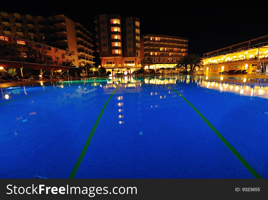 Night time photo of a swimming pool at a tropical resort